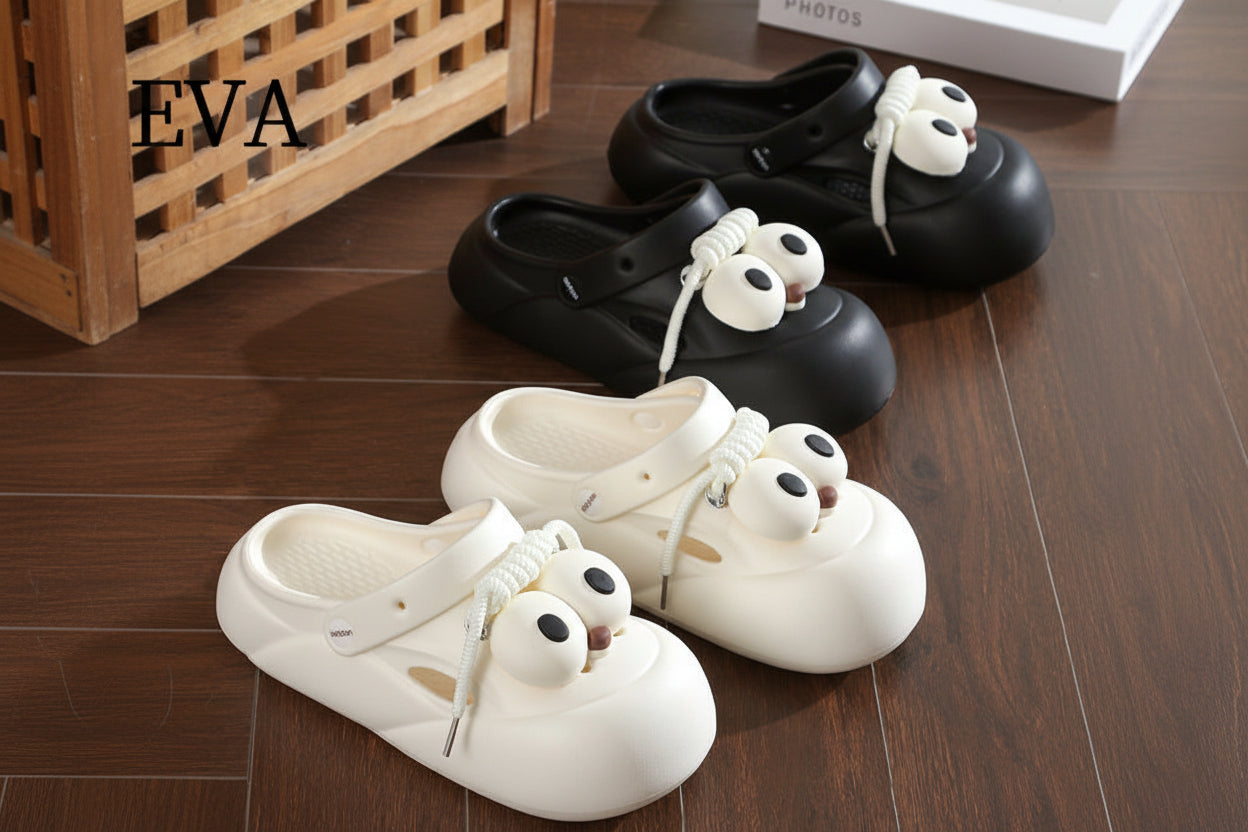 Black and white shoes with cartoonish eye designs on a wooden floor, featuring the brand 'EVA'.